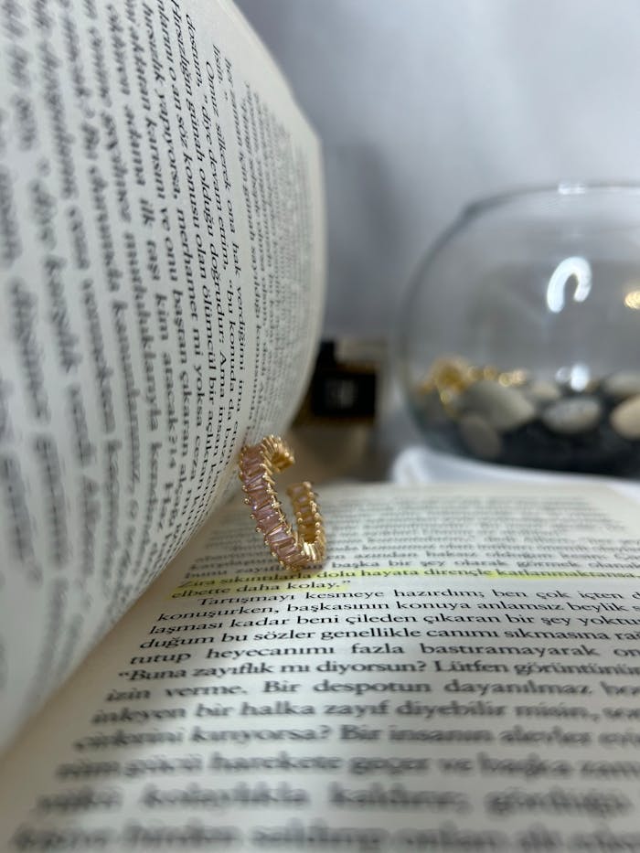 Stylish gold ring on an open book page, perfect for elegant jewelry fashion.